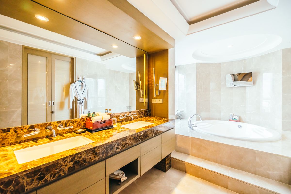Salle de bain avec un grand miroir mural au-dessus d'un double plan vasque en marbre